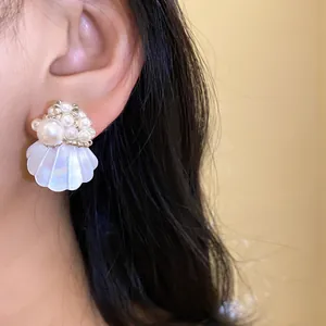 Close-up view of elegant seashell stud earring with delicate pearl bead accents