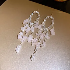 Primo piano di eleganti orecchini a nappa con pietre di cristallo rosa e strass luccicanti.
