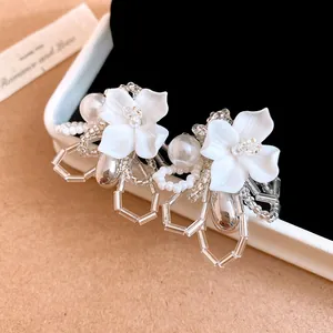 Close-up detail of white gardenia beaded earrings with pearls and silver accents
