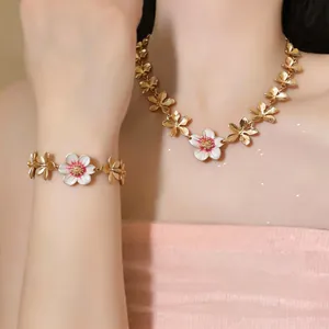 Detailed macro view of an elegant enamel flower necklace and bracelet jewelry set on a model
