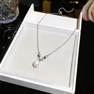 Close-up of elegant pearl pendant necklace with zircon floral accents in white box