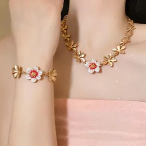 Close-up detail of elegant gold-plated enamel flower necklace and bracelet jewelry set on model