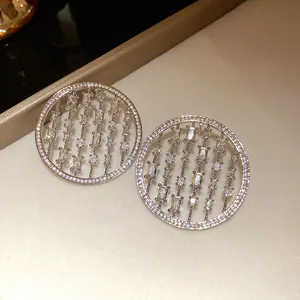 Detailed close-up of silver hollow round stud earrings with sparkling cubic zirconia