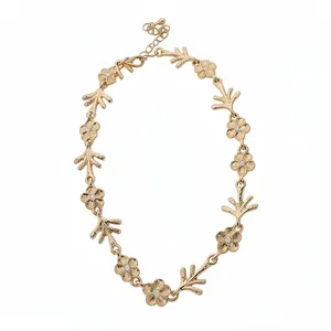Elegante collana floreale dorata con maglie irregolari e pietre centrali luccicanti.