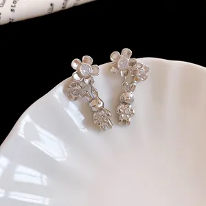 Dettaglio macro di orecchini a coniglio in argento con fiori di zircone scintillanti