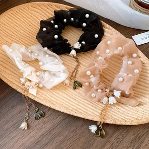 Vista dettagliata di elastici in tulle con eleganti perle finte e nappe a fiore e foglia