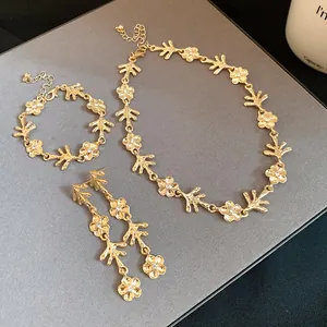 Dettaglio del set di collana e orecchini dorati con fiori irregolari ed eleganti