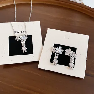 Vista dettagliata del set collana e orecchini con fiori e coniglietti in zircone argento
