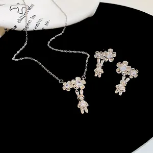 Primo piano di collana e orecchini con pendente a forma di fiore e coniglio in zircone