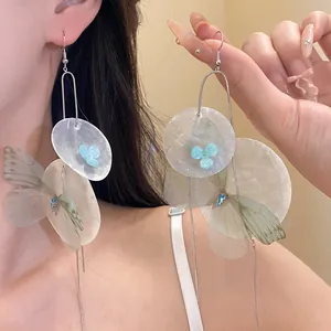 Detailed macro view of elegant chiffon butterfly and shell flower tassel drop earrings