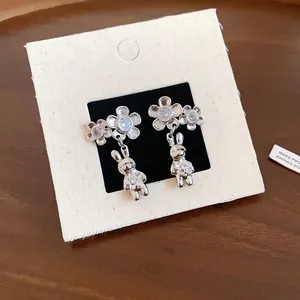 Vista dettagliata degli eleganti orecchini con fiori in zircone e ciondoli a coniglio