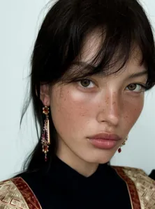 Elegant model wearing vintage palace style resin flower drop earrings in close-up view