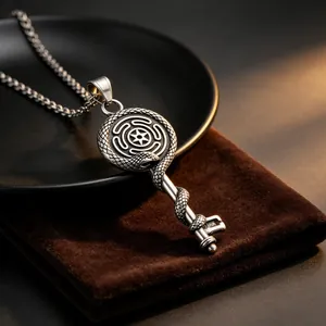 Detail view of vintage titanium steel key pendant with Ouroboros and Labyrinth motif