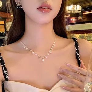 Detailed close-up showing the elegant zircon and pearl clavicle chain worn by a model