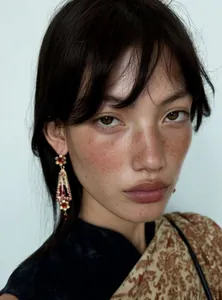 Detailed view of vintage palace style resin flower drop earrings on an Asian model