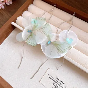 Close-up of chiffon butterfly earrings with shell flowers and long tassel chains