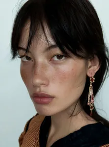 Close-up of model wearing palace-style vintage resin flower earrings.