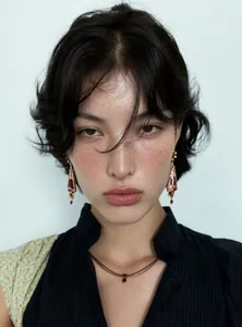 Close-up of model wearing vintage court style resin drop earrings in red floral design