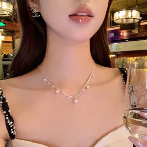 Elegant French style zircon and pearl necklace displayed on a model in warm restaurant light
