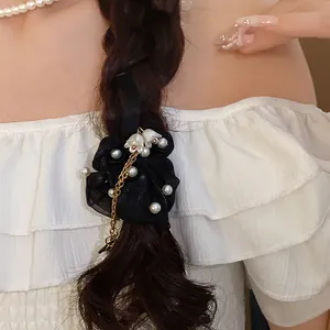 Elegante elastico in organza nera con mughetto e nappa di perle su una treccia