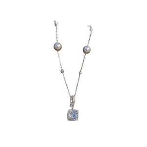 Elegante silberne Halskette mit quadratischem Zirkonia-Anhänger und zwei kleinen Perlen.