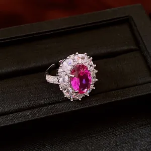 Close-up detail of a vintage oval flower ring with a radiant magenta zircon center