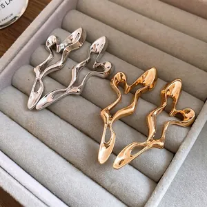 Elegant geometric hollow metal drop earrings in gold and silver set in a gray jewelry box