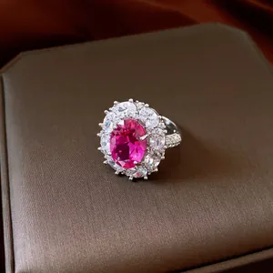 Detailed macro view of an elegant oval magenta zircon flower ring with sparkling accents
