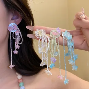 Detail showing colorful flower tassel earrings with shell accents in multiple shades