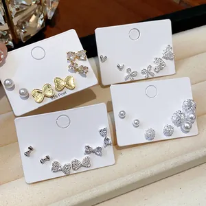 Close-up of elegant stud earring sets with pearls, zircons, and bow designs