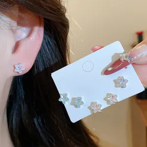 Close-up of sparkling zircon star-shaped stud earrings set on a white display card