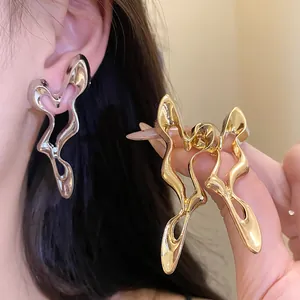 Detailed view of irregular hollow geometric earrings in silver and gold finishes