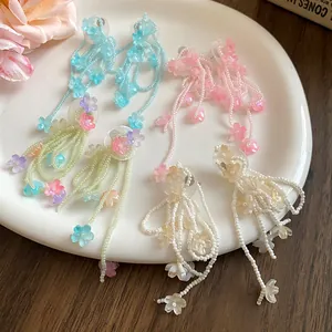 Detailed close-up showing pastel beaded flower tassel earrings in multiple soft colors.