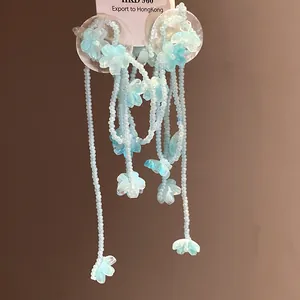 Detailed view of elegant light blue shell flower tassel earrings with pearlescent beads.