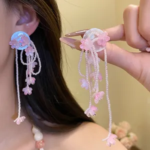 Detailed macro shot of pink shell flower tassel earrings featuring elegant long beaded strands.