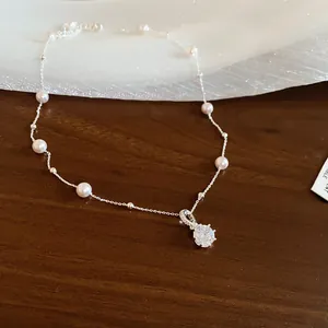 Detail einer eleganten Halskette im koreanischen Stil mit Zirkonia-Anhänger und Perlen