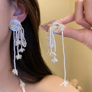 Detail view of elegant shell flower tassel earrings featuring delicate pearl strands