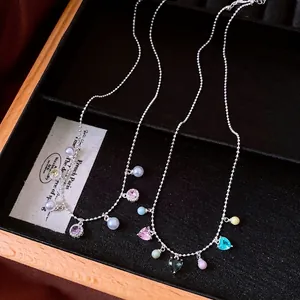 Vintage pearl necklace with colorful water drop pendants displayed on jewelry tray