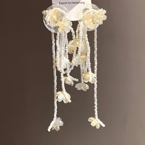 Detailed view of white shell flower tassel earrings with delicate beaded strands