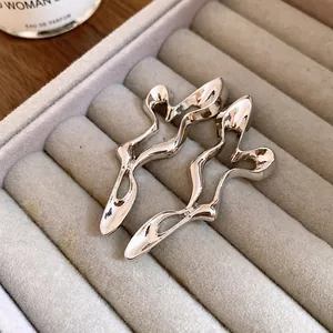 Close-up view of elegant silver-tone hollow geometric earrings in a jewelry tray
