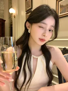 Elegant silver feather drop earrings with diamonds worn by an Asian model in a setting.