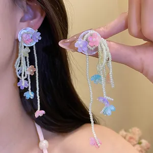 Detailed view of silver needle pearl tassel earrings with colorful shell flowers.