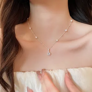 Elegante silberfarbene Choker-Halskette mit rundem Zirkonia-Anhänger und Perlen am Model