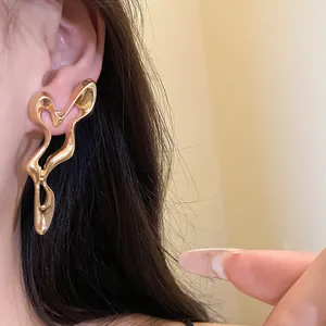 Close-up detail of stylish gold metal geometric hollow drop earrings for women