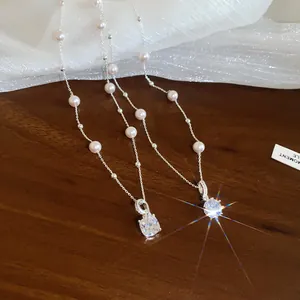 Elegante Detailansicht von funkelndem Zirkon-Anhänger und Perlenhalskette auf dunklem Holz