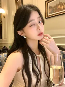 Elegant feather stud earrings with sparkling diamonds on an Asian model