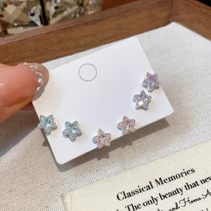 Close-up of sparkling zircon star stud earrings in various colors on a display card