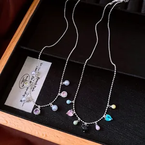 Close-up of vintage silver bead necklaces with colorful crystal heart and pearl charms