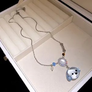 Macro della collana con ciondoli a forma di cane e osso con dettagli in zircone.