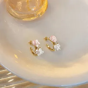 Detailed macro view of Korean style pink and white glass heart C-shaped stud earrings